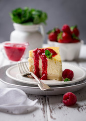 Delicious homemade cheesecake served with strawberry sauce, fresh berries and mint