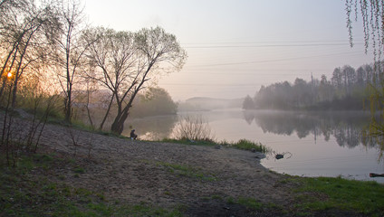 Man catch the fish at foggy sunrise