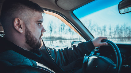 bearded man sitting behind the wheel of the Russian