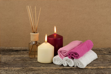 Beautiful composition with burning candles and spa towels on wooden background, zen and relax concept