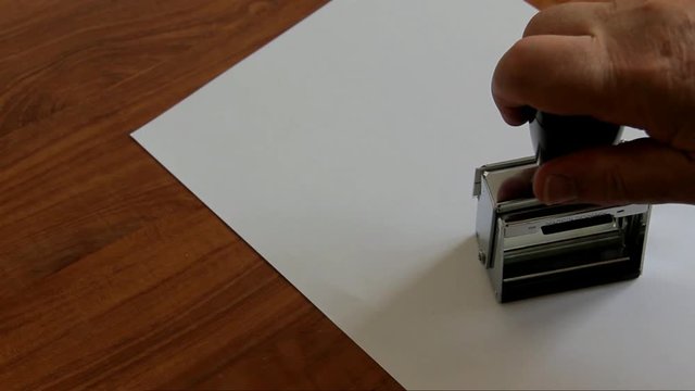 Police Officer Puting a Stamp Validated on Clean Sheet of Paper