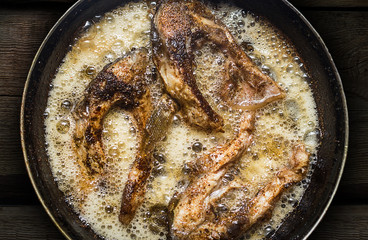 Fish in a frying pan. horizontal view from above. On the wood