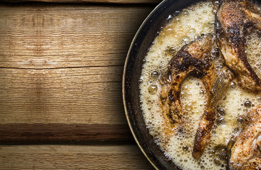 Fish in a frying pan. horizontal view from above. On the wood