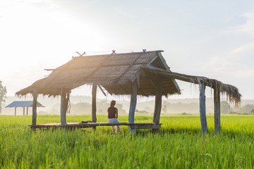 Woman sitting in the Cottage at Rice Field