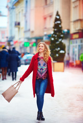 happy beautiful woman walking on crowded street in winter