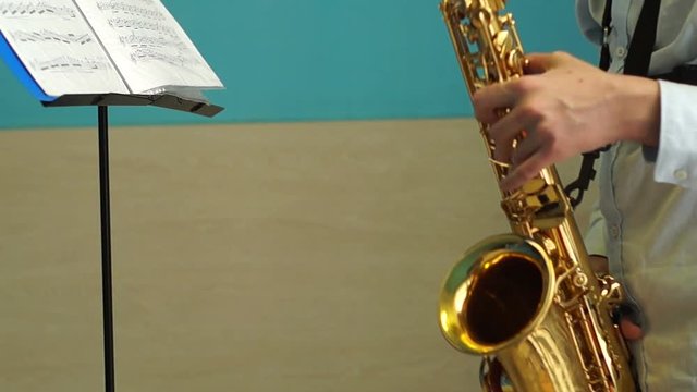 Teenager plays saxophone reading music