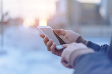 Man's hand using cellphone outdoor, Man typing text message on smart phone, Blurred background, Shallow DOF