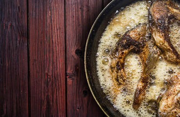 Fish in a frying pan. horizontal view from above. On the wood