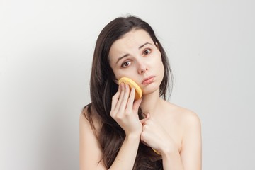 sad brunette wiping her face with a sponge