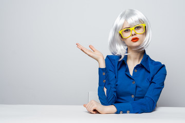 woman wearing yellow glasses showing hand to side