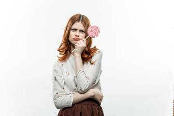 offended woman holds a round candy in her hand