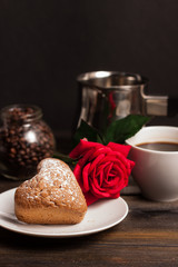 cupcake in a plate, a red rose and a cup with a drink
