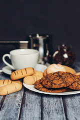 many different cookies on a saucer and a cup of coffee