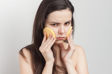sad woman pressed two sponge to her cheeks