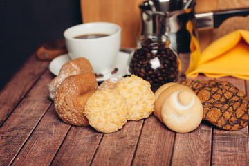 different biscuits on a wooden table and a drink with a jar of coffee