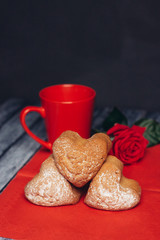 donuts with sugar powder and red mug with flower on napkins