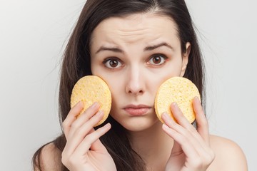 round sponge and a surprised woman