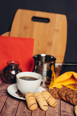 top view, drink in a cup, cookies and a board with a jar and a ladle in the background