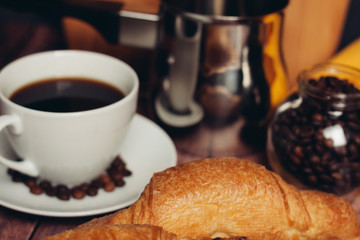 drink in a cup, croissant and coffee beans