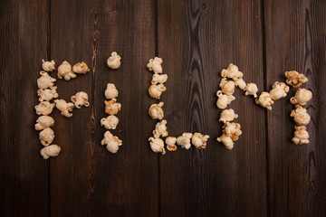 Fototapeta na wymiar word popcorn on a wooden board