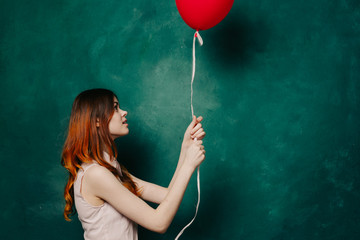 red-haired woman holding a red air balloon