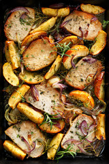 Roasted pork chops with the addition of apples and onions