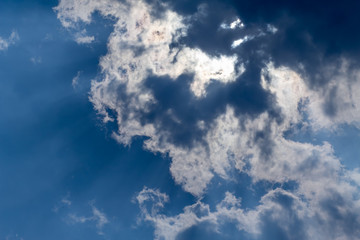 sun with sunbeams in a beautiful cloudy sky. blue sky is covered by white clouds