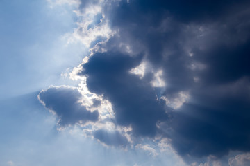 sun with sunbeams in a beautiful cloudy sky. blue sky is covered by white clouds
