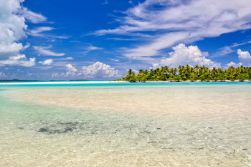 Stunning view of a beach on One Foot Island, also called Tapuaetai, in the lagoon of Aitutaki, Cook Islands, in the South Pacific Ocean. Clear water, palm trees and white sand beach on a sunny day. 