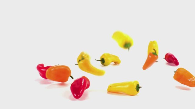Peppers tumble onto a white cyc in slow motion