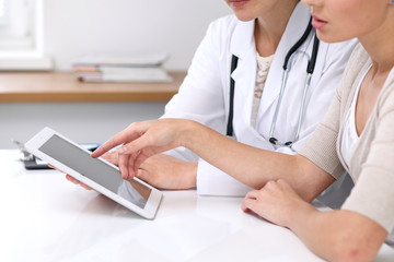  Close up of a doctor and  patient  sitting at the desk. Physician pointing into laptop computer. Medicine and health care concept