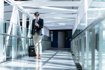 young man carrying a carry bag with him on passage of modern building