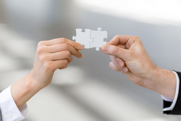man and woman hand holding jigsaw puzzles, business matching concept - obrazy, fototapety, plakaty