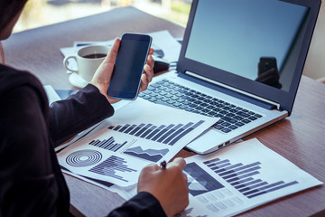 Close Up of woman hands using mobile phone and laptop computer with blank copy space screen for your advertising text message or content business in the Vintage effect.