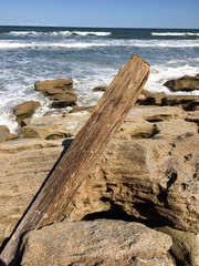 Wooden pole on rock beach