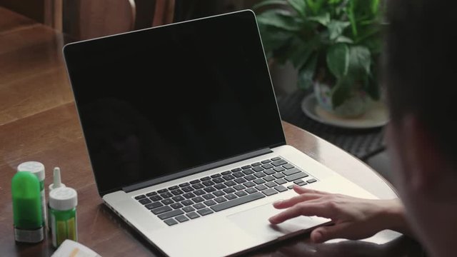 Over the shoulder shot of a laptop with prescription drugs