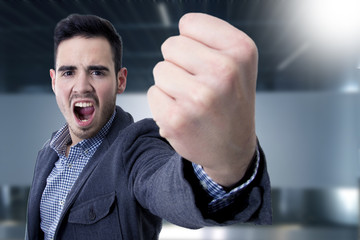 young man yelling with his fist in the foreground