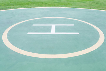 Close - up empty helipad and green grass