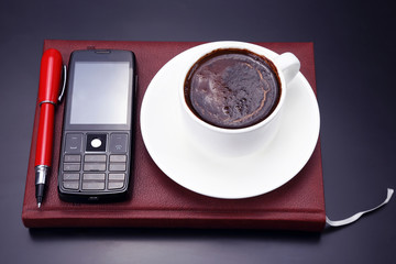 black coffee, mobile and pen on the table from a business person