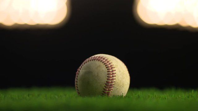 A baseball displayed under the lights.