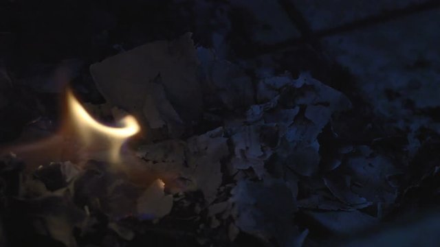 Fire and ashes. Papers and wood burning in a night campfire.