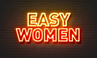 Easy women neon sign on brick wall background.