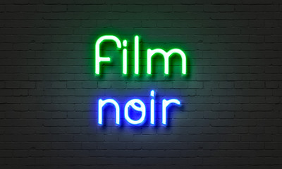 Film noir neon sign on brick wall background.