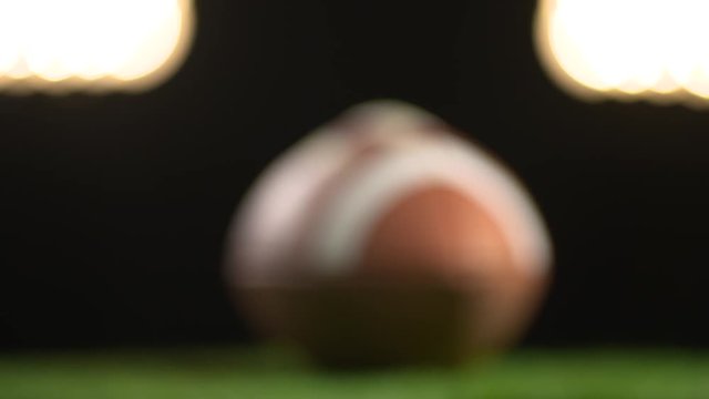 A football under the stadium lights are featured in the football background.