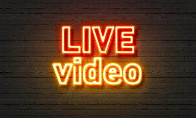Obraz premium Neonowy znak wideo na żywo na tle ściany z cegły.