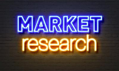 Market research neon sign on brick wall background.