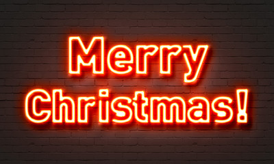 Merry Christmas neon sign on brick wall background.