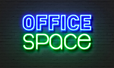Office space neon sign on brick wall background.