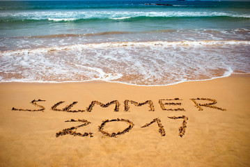 Inscription on wet sand Summer 2017. Concept photo of summer vacation on the tropical island ocean beach.
