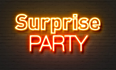 Surprise party neon sign on brick wall background.